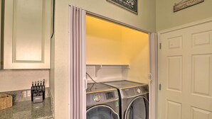 A laundry area with two front-loading washers and dryers, a basket, and a sign above the dryers. - North Tucson Home w/ Patio by Catalina State Park! (Tucson)