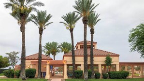 A building with a tiled roof, palm trees, and a well-maintained lawn. - North Tucson Home w/ Patio by Catalina State Park! (Tucson)