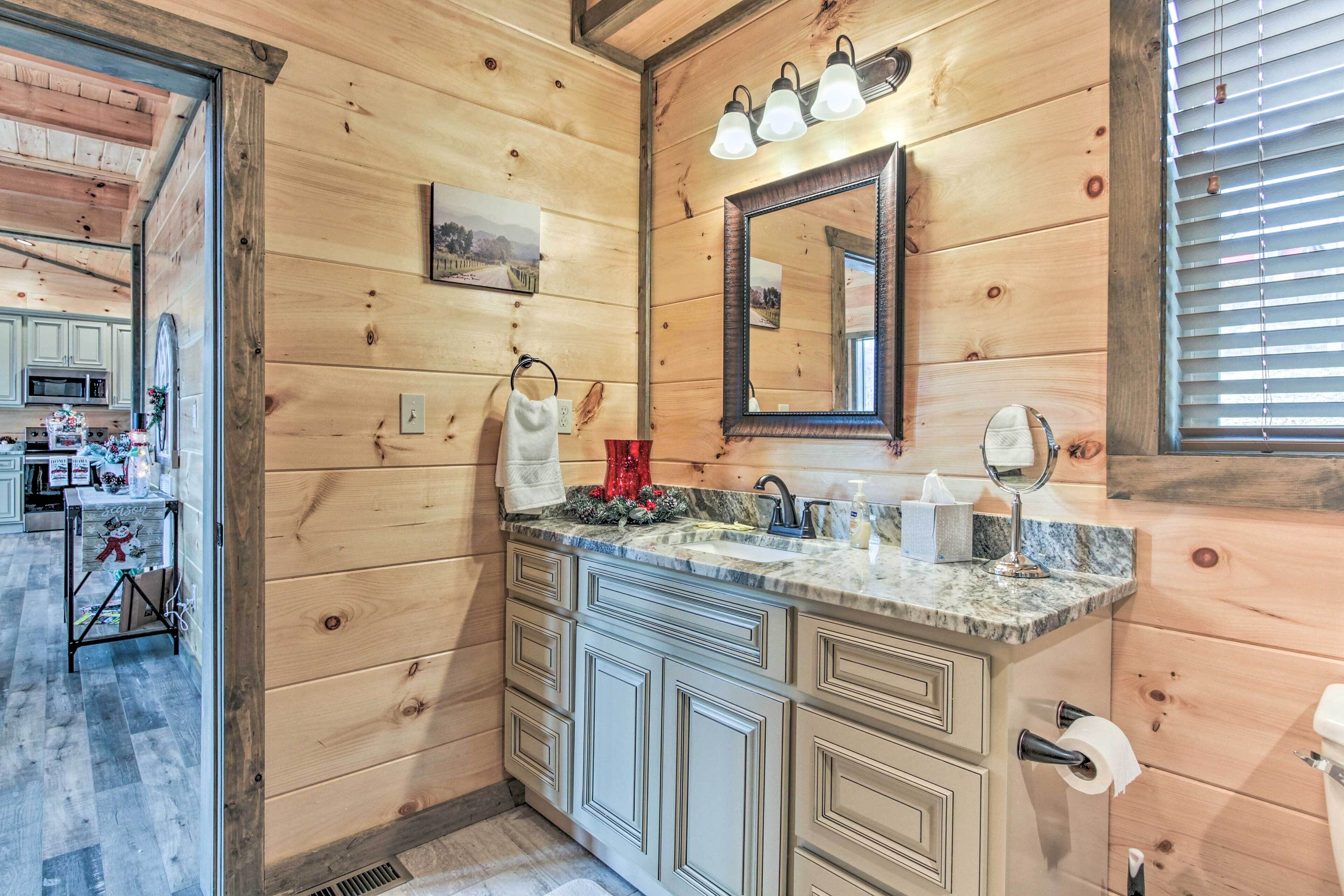 A wooden-paneled bathroom with a sink, mirror, and towel rack.