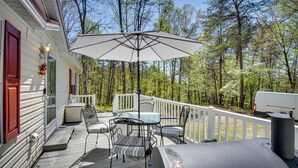 A deck with outdoor furniture, a grill, and a white umbrella. - Walk to Lake Chatuge! Hayesville Cabin w/ Fire Pit (Hayesville)