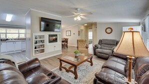 A spacious living room with leather sofas, a coffee table, and a TV mounted on the wall. - Walk to Lake Chatuge! Hayesville Cabin w/ Fire Pit (Hayesville)