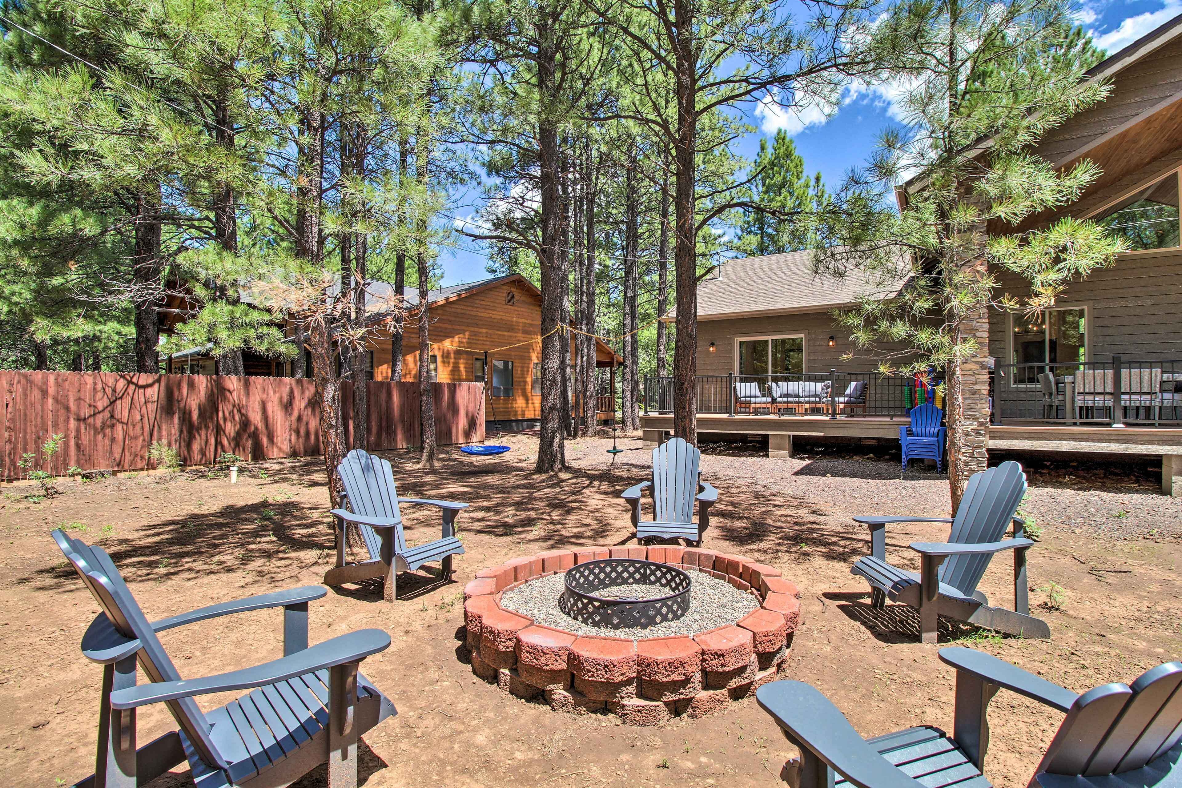 A backyard with a fire pit, Adirondack chairs, and a wooden deck.