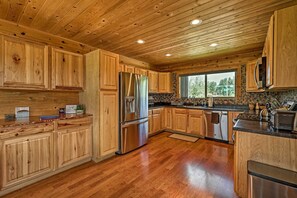 A spacious kitchen with wooden cabinets, stainless steel appliances, and a large window providing natural light. - 9 Mi to Rainbow Lake: Mtn Getaway w/ Bbq! (Pinetop)