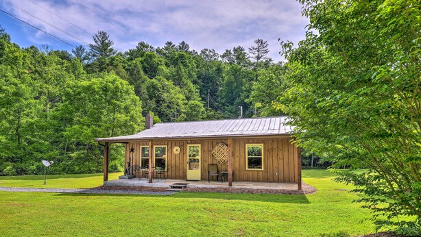 A wooden cabin with a porch, large windows, and a covered outdoor seating area. - Bonfires & Bbqs! Creekside Retreat in Marshall (Marshall)