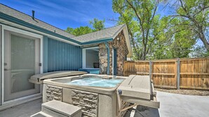 A backyard with a hot tub, stone pillar, and a wooden fence. - Stylish Basecamp 6850' Near Downtown Williams! (Williams)