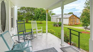 A porch with rocking chairs and a view of a well-maintained lawn and a small wooden building. - 'grandma's Farm House' on 125 Acres w/ Fire Pit! (Beattyville)