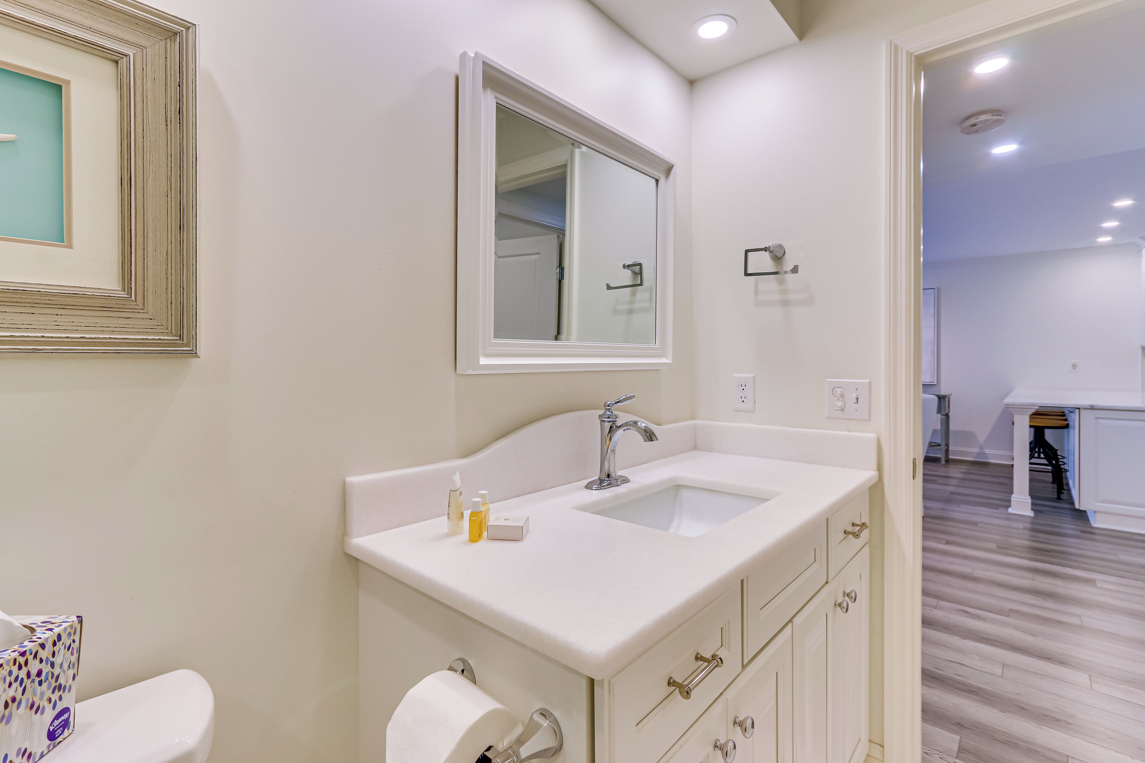 Une salle de bain moderne avec un lavabo blanc, un miroir et des toilettes.