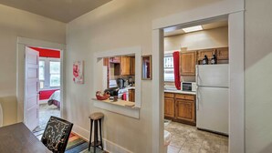 A kitchen with wooden cabinets, a white refrigerator, and a countertop with a kettle and a toaster.