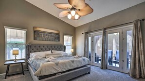 A bedroom with a large bed, a ceiling fan, and a view through the glass doors. - Beautiful Backyard: Comfortable Phoenix Getaway! (Phoenix)