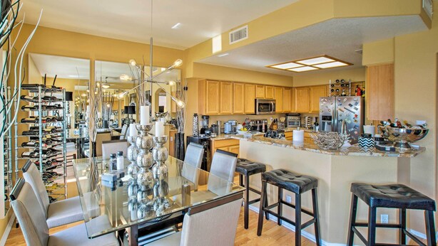 A spacious kitchen with modern appliances, a glass dining table, and bar stools. - Luxury Glendale Getaway w/ Private Hot Tub & Patio (Glendale)
