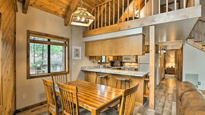 A spacious kitchen with a wooden island, a dining area with a wooden table and chairs, and a cozy seating area with a leather couch. - 1 Mi to Lake: Secluded Cabin w/ Deck in Munds Park (Munds Park)