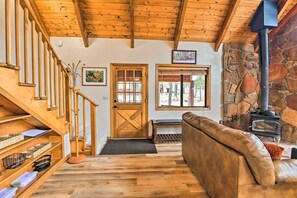 A wooden staircase leading to a door, a stone fireplace, and a leather sofa in a rustic interior. - 1 Mi to Lake: Secluded Cabin w/ Deck in Munds Park (Munds Park)
