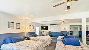 A room with three beds, a desk, and a ceiling fan. - Relaxing Surfside Bunkhouse - Walk to the Beach! (Freeport)