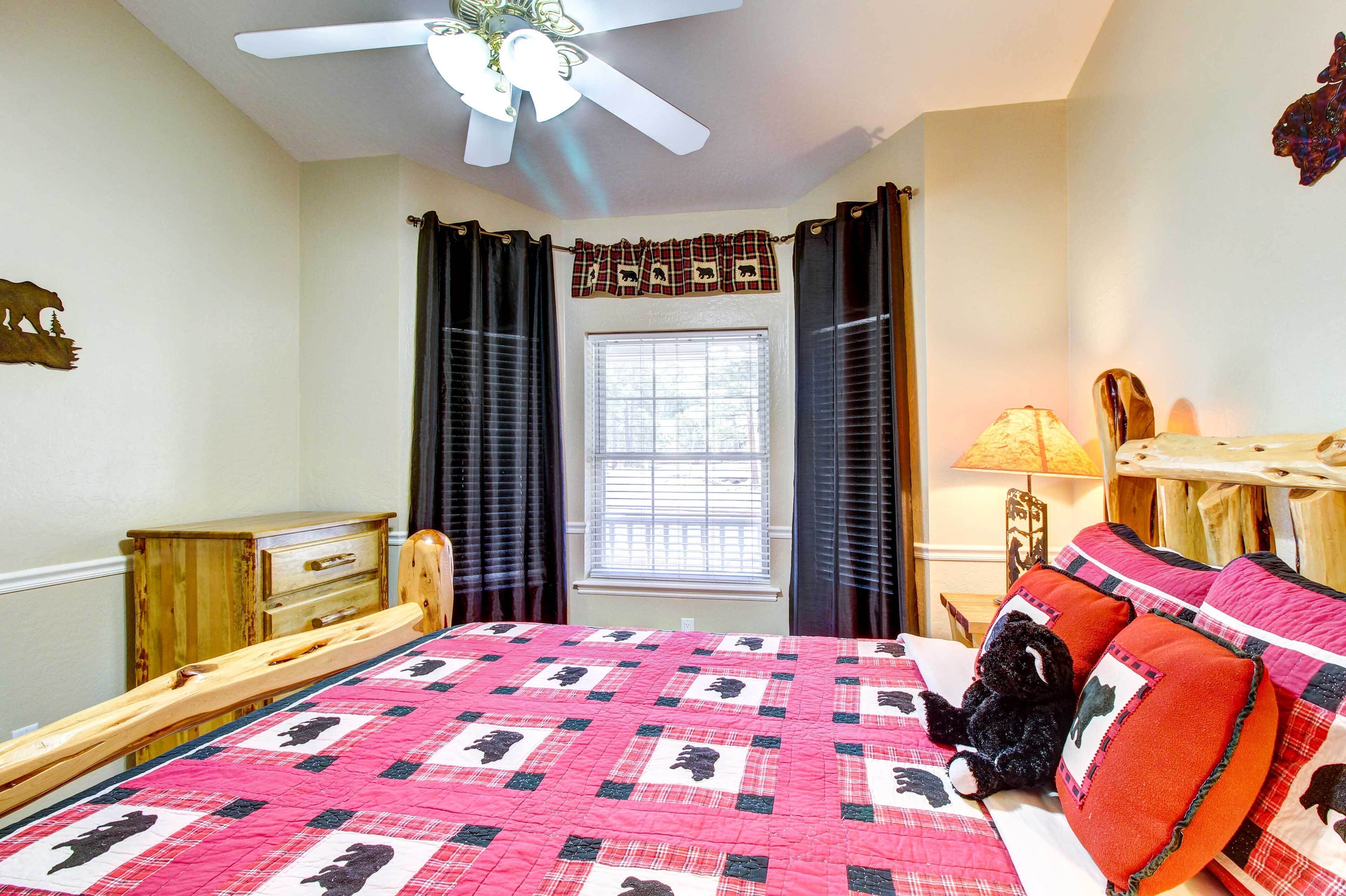 A bedroom with a bed, a wooden dresser, a window with curtains, and a ceiling fan.