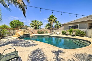 A backyard with a swimming pool, palm trees, and outdoor furniture. - Pool Table, Yard & Grill: Luxe Queen Creek Escape (Queen Creek)