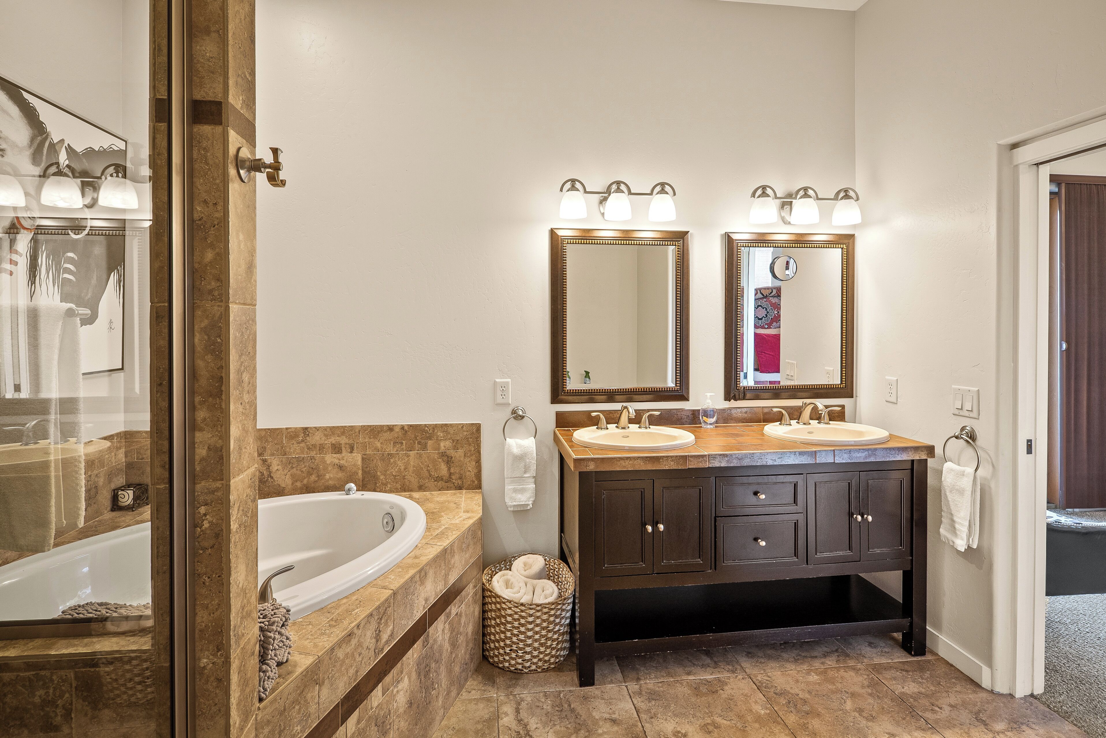 A modern bathroom with a double sink vanity, a large mirror, and a walk-in shower.