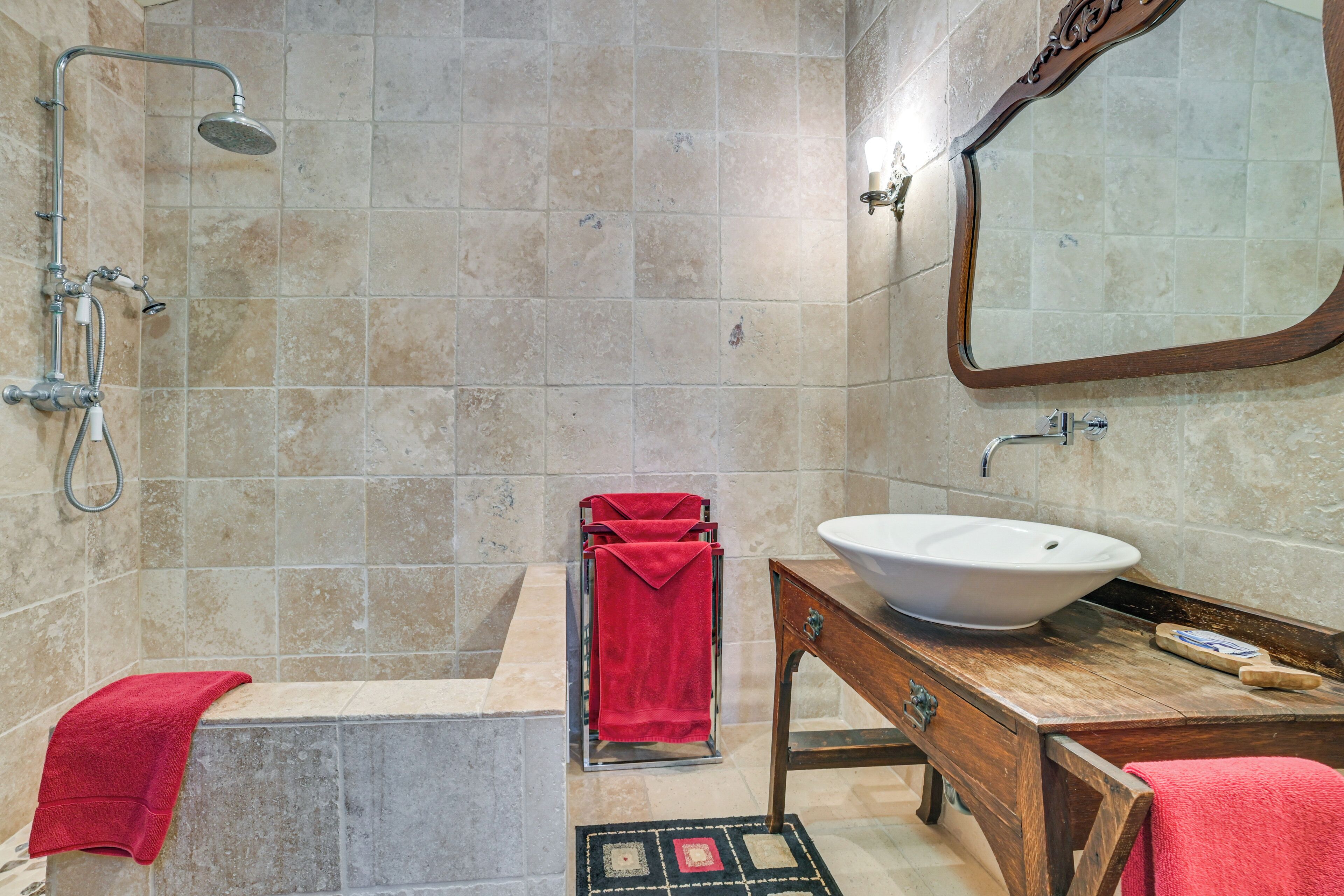 Un baño con bañera, lavabo, espejo y ducha.
