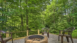 A stone fire pit surrounded by wooden chairs in a forested area. - 10 Mi to Grandfather Mountain: 'wolfe Creek Cabin' (Newland)