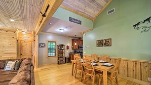 A cozy cabin interior with a wooden dining table, chairs, a couch, and a kitchen area. - 10 Mi to Grandfather Mountain: 'wolfe Creek Cabin' (Newland)