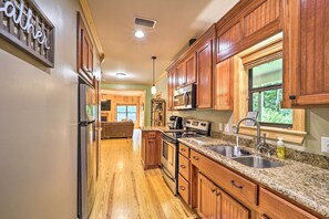 A kitchen with wooden cabinets, stainless steel appliances, and a granite countertop.