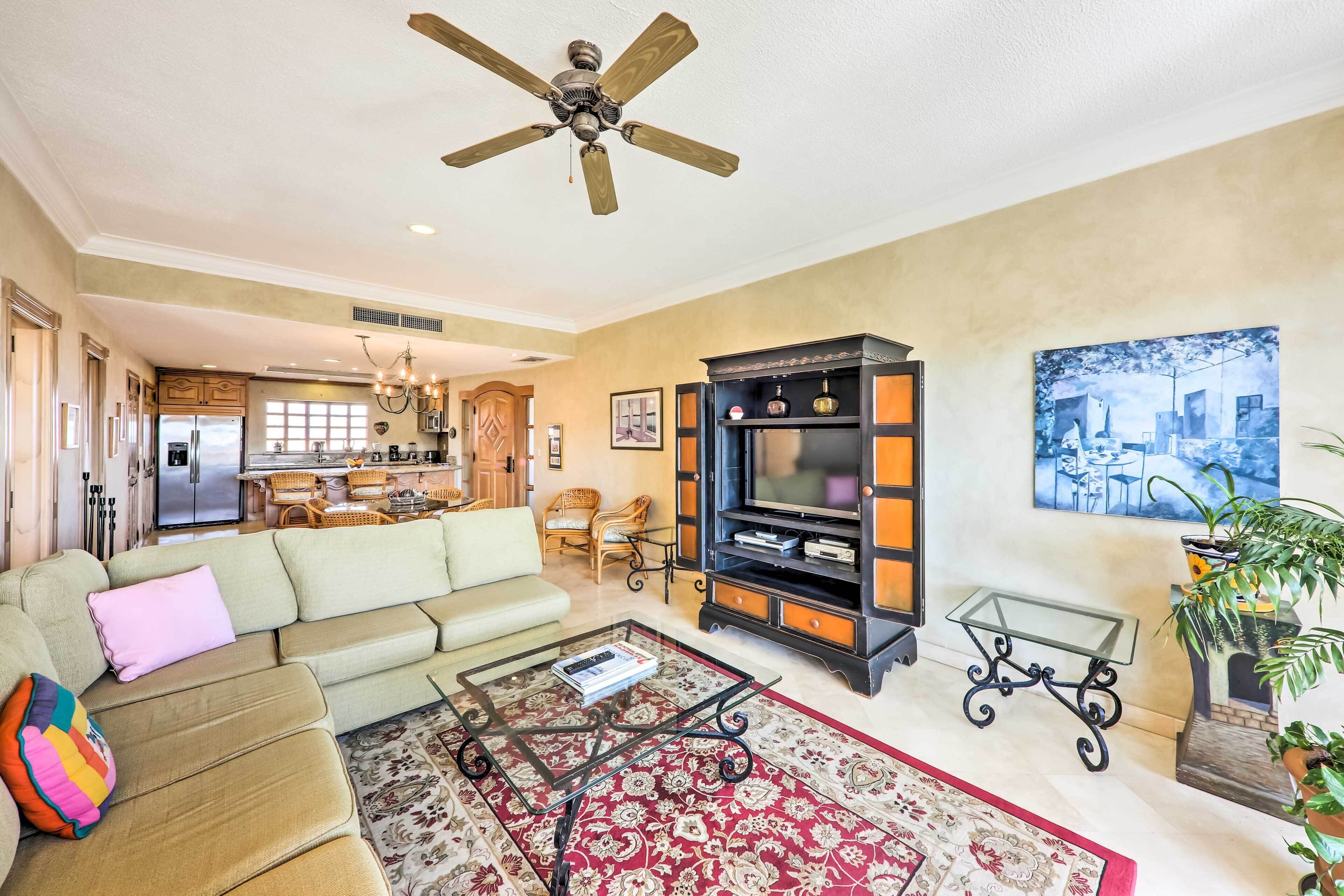 A spacious living room with a sofa, coffee table, and a television stand.