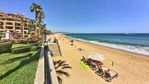 Un complexe hôtelier en bord de mer, doté d’une piscine, de palmiers et offrant une vue sur l’océan.