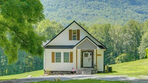 A small, single-story house with a gabled roof, a front porch, and a front door. - Modern Appalachian Vacation Rental w/ River Access (Pennington Gap)