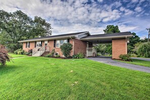A two-story brick house with a covered front porch, a small attached garage, and a well-maintained lawn. - Family-friendly Getaway w/ Fire Pit & 2 Kayaks! (Bridgewater)