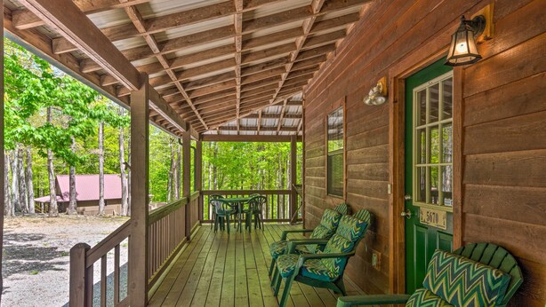 Eine Holterrasse mit grünen Stühlen, einem Tisch und einer grünen Tür.