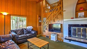 Ein gemütliches Wohnzimmer mit einer Ledersofa, einem Holztisch, einem Kamin und einem Fernseher.