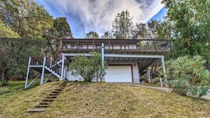 Una casa de dos pisos con un balcón, un garaje y una escalera que lleva a la entrada.