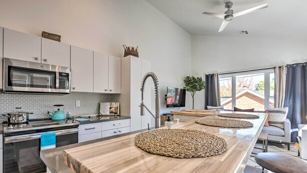 A modern kitchen with stainless steel appliances, a wooden island, and a ceiling fan. - Modern Midtown Haven w/ Garage: Mt Rose Day Trips! (Reno)