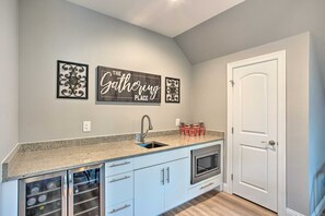 Una cocina con encimera de granito, horno empotrado y puerta blanca.