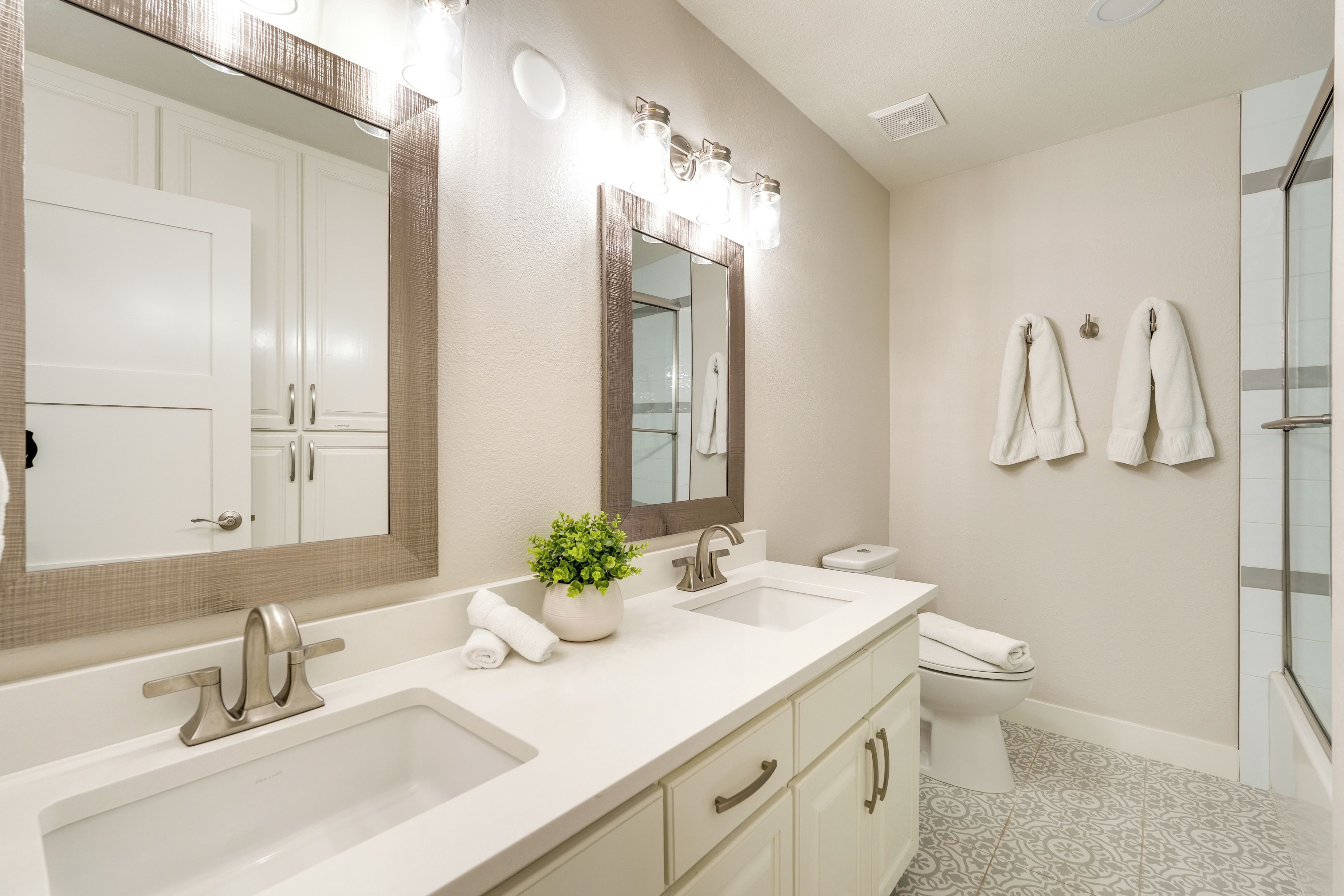 Un baño moderno con lavamanos doble, un espejo grande y una zona de ducha.