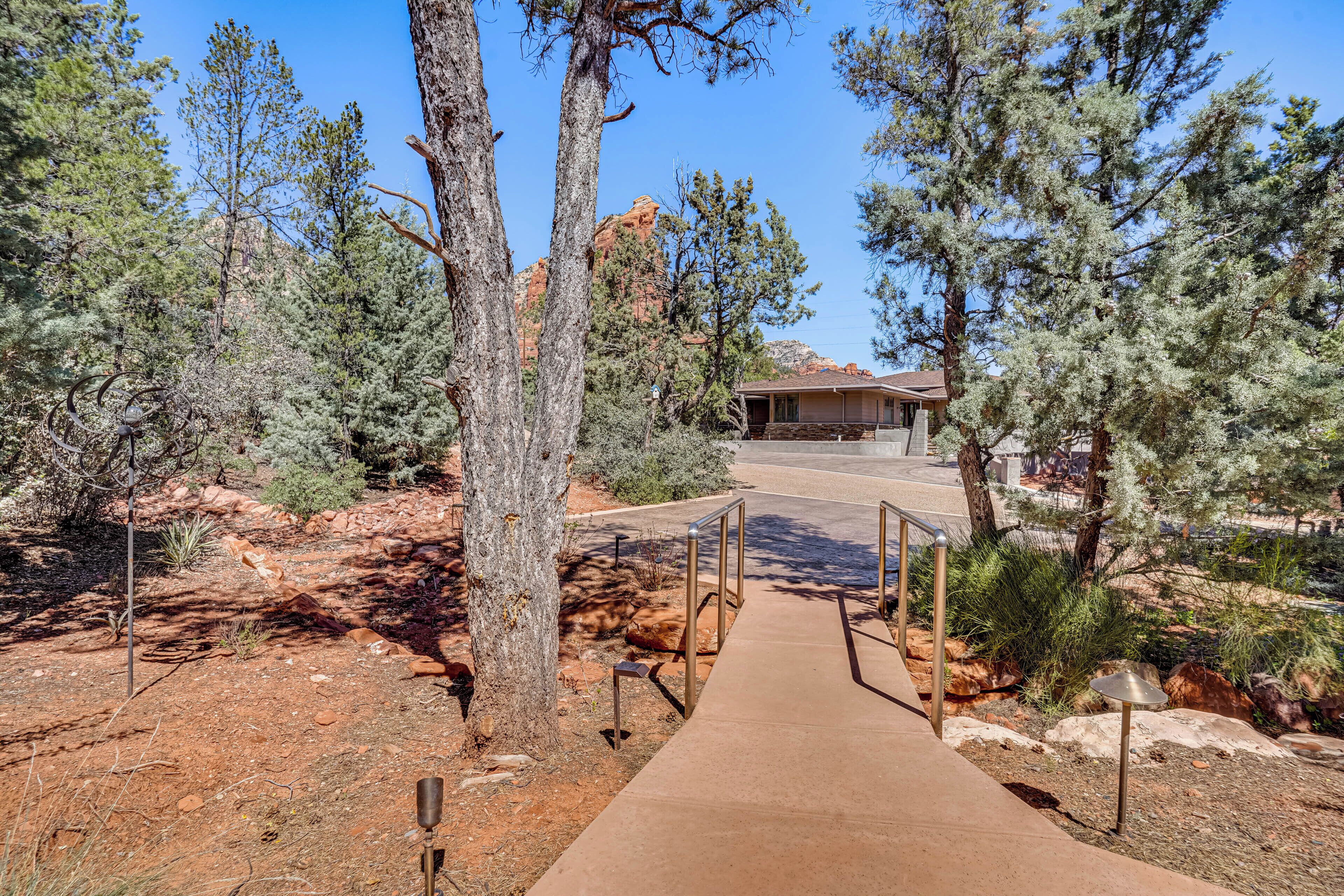 A pathway leading to a building surrounded by trees and rocky terrain.
