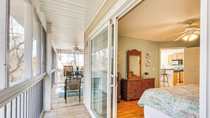 A bedroom with a large bed, a dresser, and a sliding glass door leading to a balcony. - Marina & Beach Club Access: Condo in Southport (St. James)