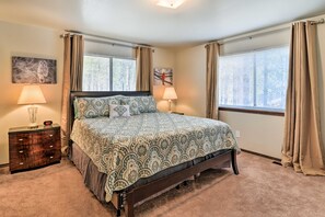A bedroom with a bed, two bedside lamps, a nightstand, and a window with curtains. - Flagstaff Home w/ Back Deck - 5 Mi to Downtown (Flagstaff)