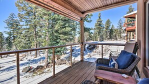 A wooden deck with wicker furniture and a view of a snowy landscape and trees. - Spacious Angel Fire Home w/ Deck & Resort Perks! (Angel Fire)