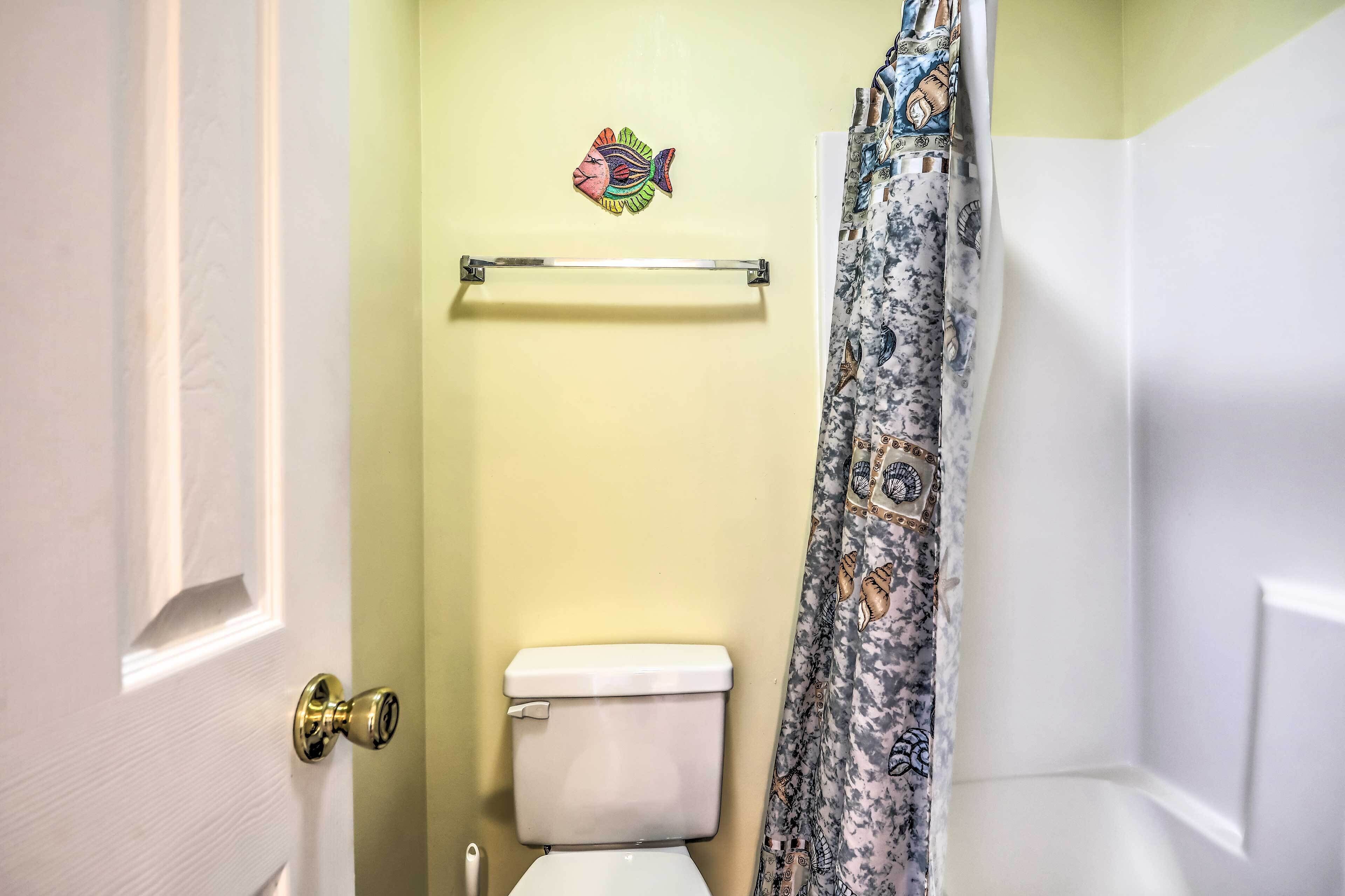 A bathroom with a toilet, a towel rack, and a shower curtain.