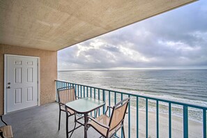 A balcony with a table and chairs overlooking the ocean. - Cozy Beachfront Escape w/ Pool & Gulf Access! (Gulf Shores)