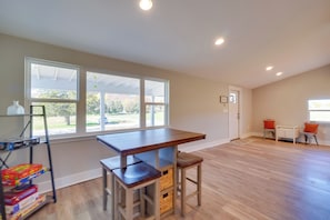 A spacious room with a large window, a wooden table, and two chairs.