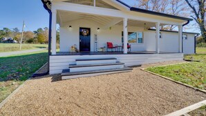 A single-story house with a covered porch, a front door with a wreath, and a sign that reads "HOME." - Scenic Home on 20-acre Farm: Families Welcome (Cleveland)