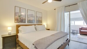 A bedroom with a bed, a nightstand, a ceiling fan, and a window with curtains. - Walk to Papago Park: Condo w/ Community Perks! (Scottsdale)