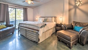 A bedroom with a bed, a sofa, a coffee table, a ceiling fan, and a window with curtains. - Dog-friendly Kingsland Rental on Lake Lbj! (Kingsland)