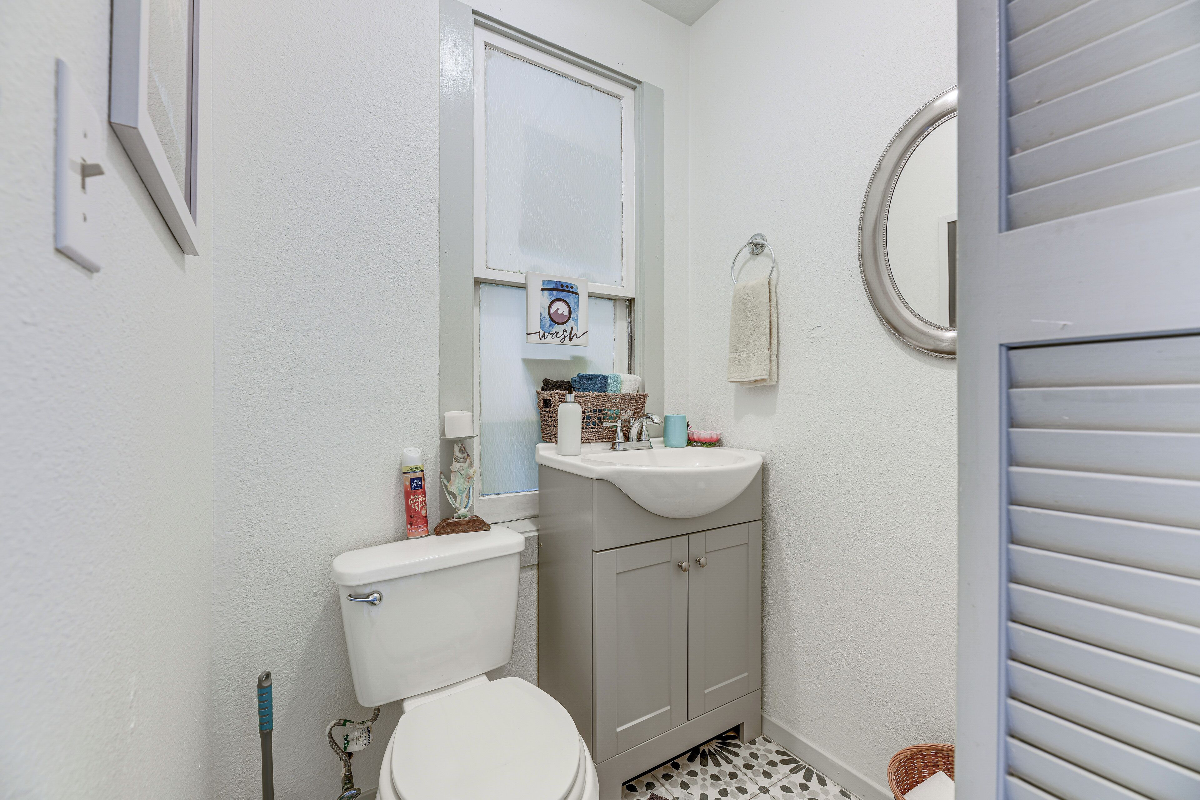 Une petite salle de bain avec des toilettes, un lavabo et un miroir.