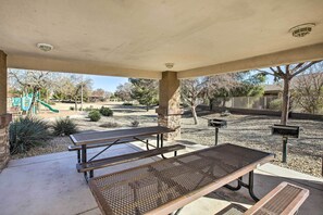 An outdoor patio area with picnic tables and a playground in the background. - Litchfield Park Home w/ Private Patio & Yard! (Litchfield Park)
