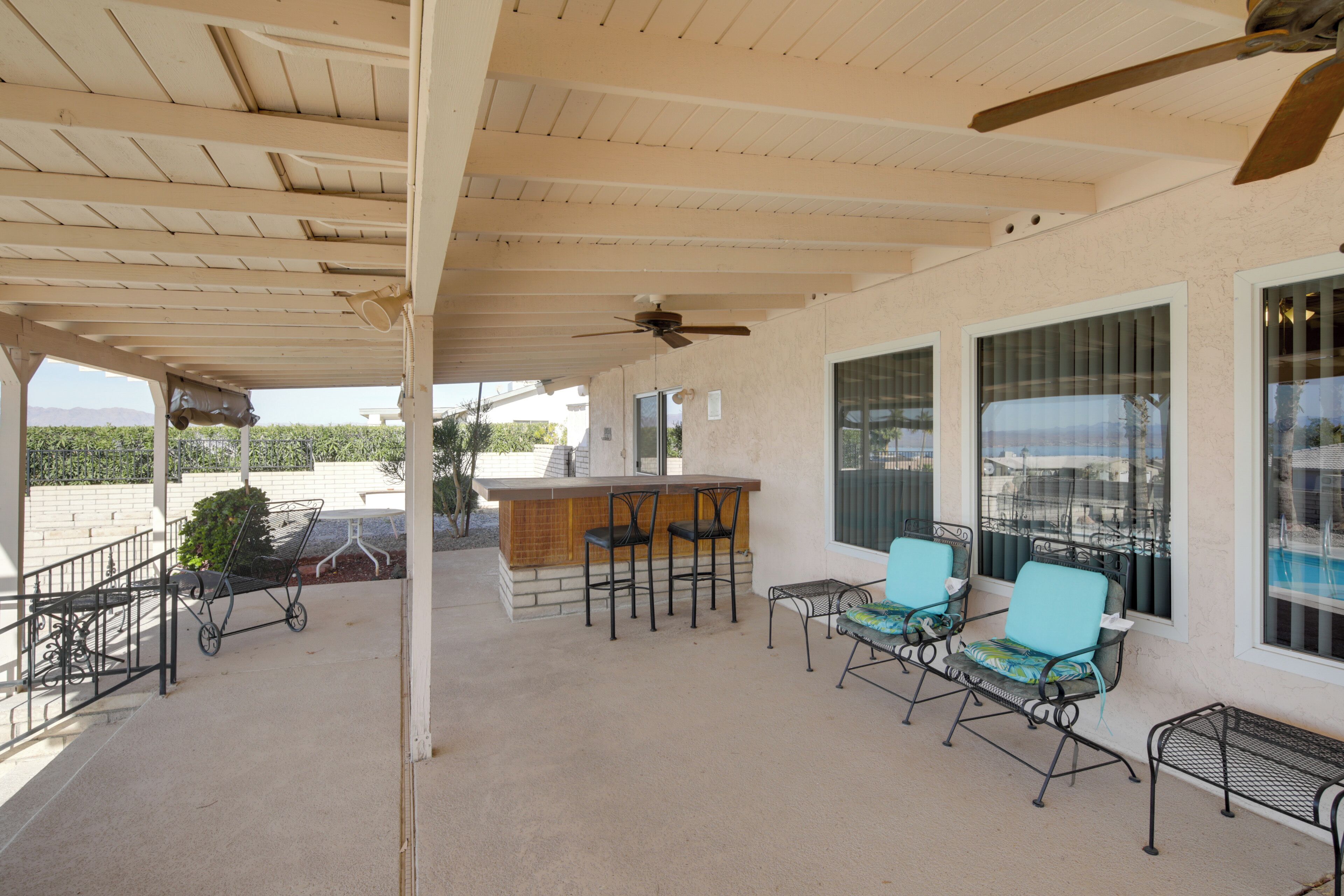 A covered patio area with a bar and outdoor seating.