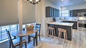 A modern kitchen with a large island, dark cabinets, and a built-in oven.