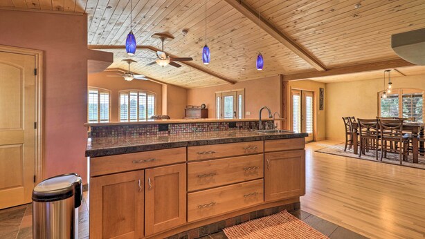 A spacious kitchen with wooden cabinets, a granite countertop, and a large island.