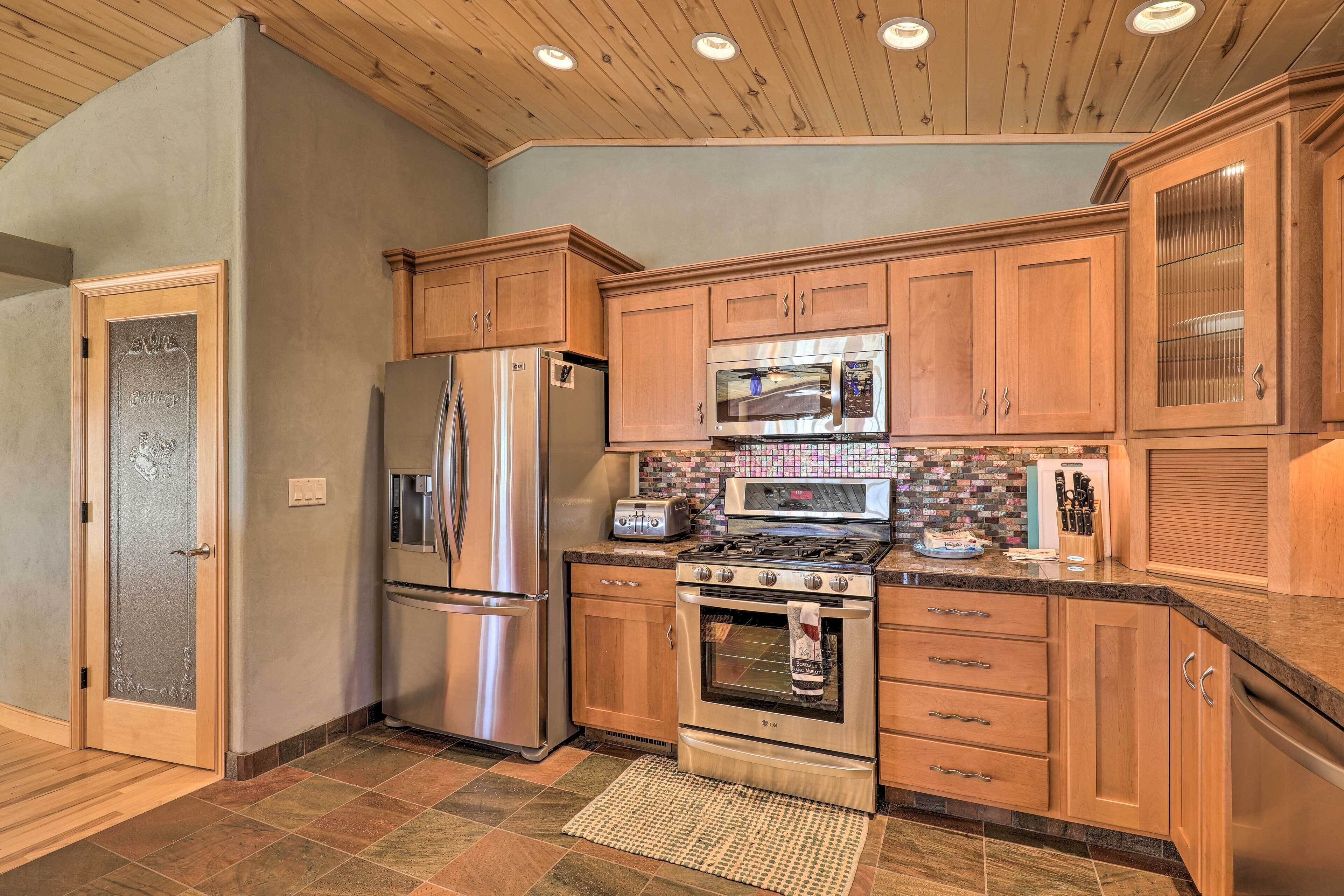 A kitchen with wooden cabinets, stainless steel appliances, and a tiled backsplash.